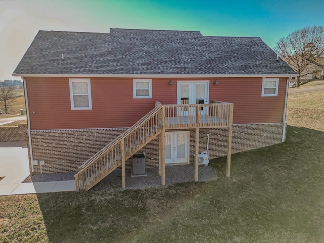 rear view of house featuring french doors, a yard, a deck, and central air condition unit