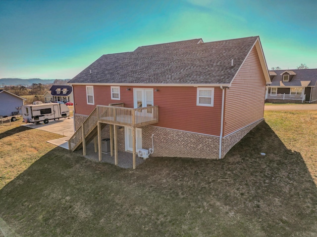 back of property with cooling unit, a deck, a yard, and french doors