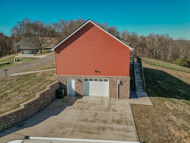 view of side of home with a garage and a lawn