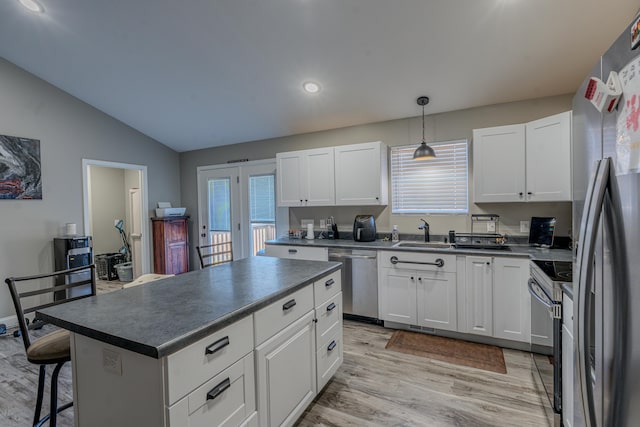 kitchen featuring a center island, white cabinets, sink, a kitchen bar, and stainless steel appliances