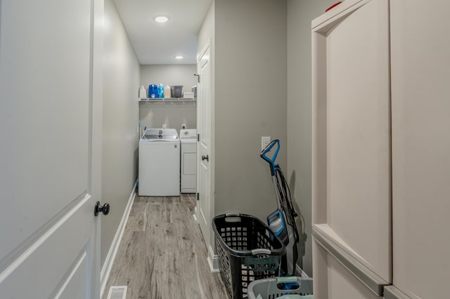 laundry room featuring independent washer and dryer and light hardwood / wood-style floors