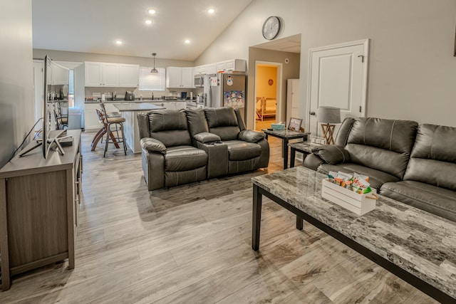 living room featuring light hardwood / wood-style floors and high vaulted ceiling