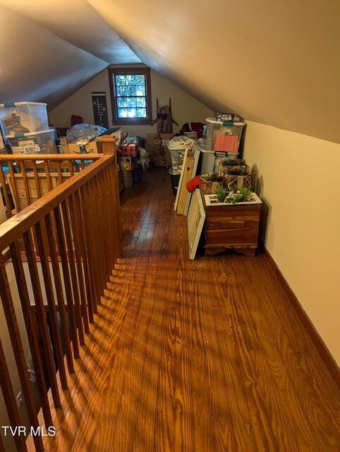 bonus room with dark wood-type flooring and lofted ceiling