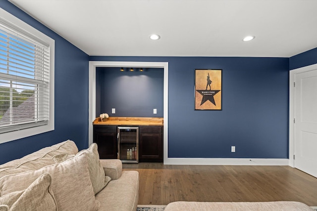 living room featuring bar, beverage cooler, and hardwood / wood-style flooring