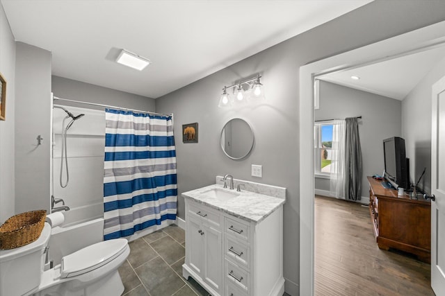 full bathroom featuring tile patterned floors, vanity, vaulted ceiling, shower / bath combo with shower curtain, and toilet