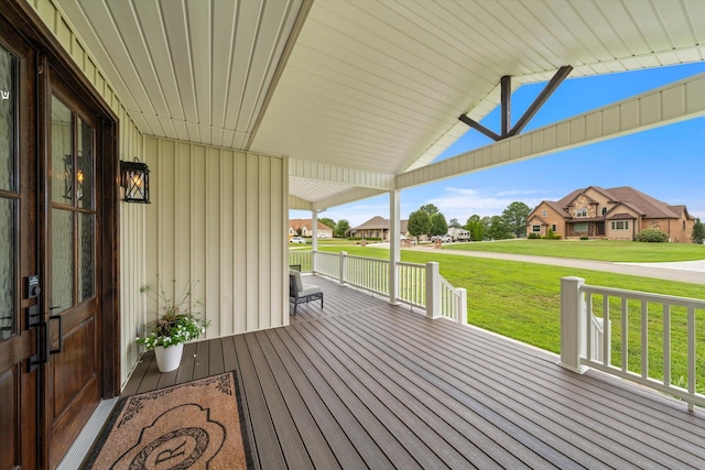 wooden terrace with a porch and a lawn