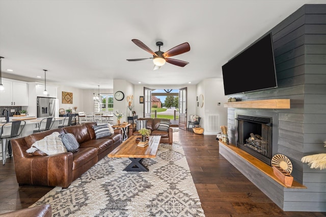 living room with dark hardwood / wood-style floors, ceiling fan, and sink