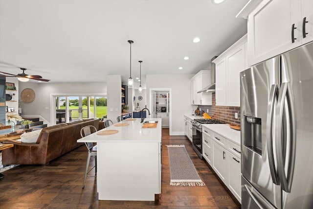 kitchen with white cabinetry, an island with sink, stainless steel appliances, and ceiling fan