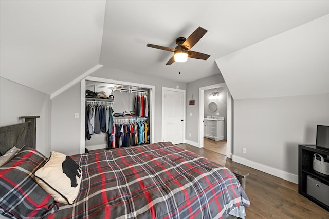 bedroom with vaulted ceiling, ceiling fan, connected bathroom, dark hardwood / wood-style floors, and a closet