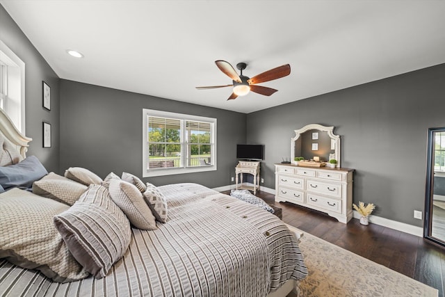 bedroom with ceiling fan, dark hardwood / wood-style flooring, and multiple windows