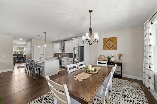 dining room with dark hardwood / wood-style floors, sink, and a chandelier