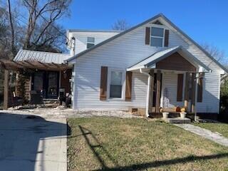 bungalow featuring covered porch and a front yard