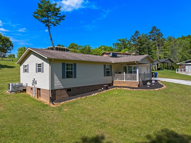 exterior space featuring roof with shingles, an attached garage, crawl space, cooling unit, and a yard