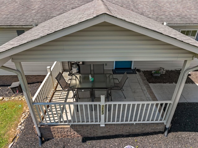 exterior space featuring roof with shingles, a patio, outdoor dining area, and fence private yard