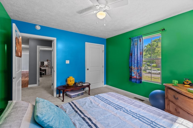 bedroom featuring ceiling fan, a textured ceiling, visible vents, baseboards, and carpet