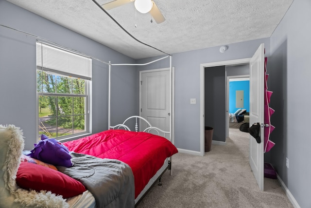 carpeted bedroom featuring a ceiling fan, a textured ceiling, and baseboards