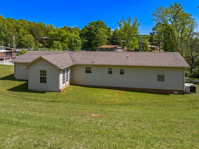 back of house featuring a yard, central AC, and roof with shingles