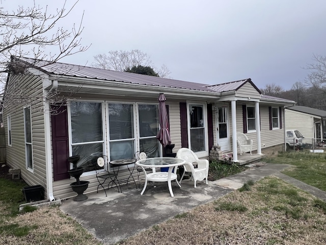 rear view of house featuring a patio area and metal roof