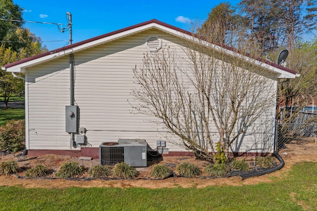view of side of home featuring fence and central AC