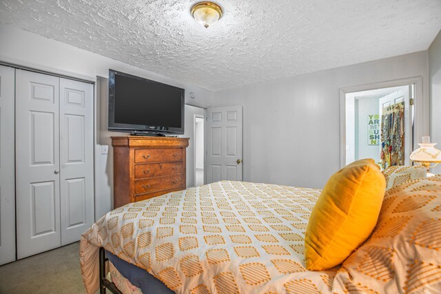 carpeted bedroom with a textured ceiling and a closet