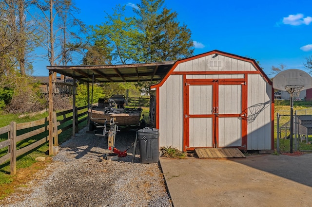 view of shed with fence and a carport