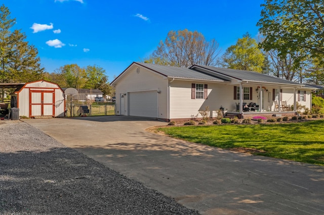view of front of house with a storage shed, a front lawn, an attached garage, a porch, and metal roof