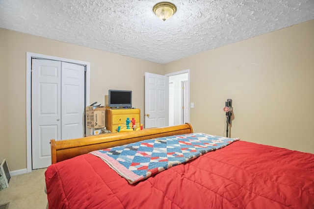 bedroom with baseboards, carpet flooring, a textured ceiling, and a closet