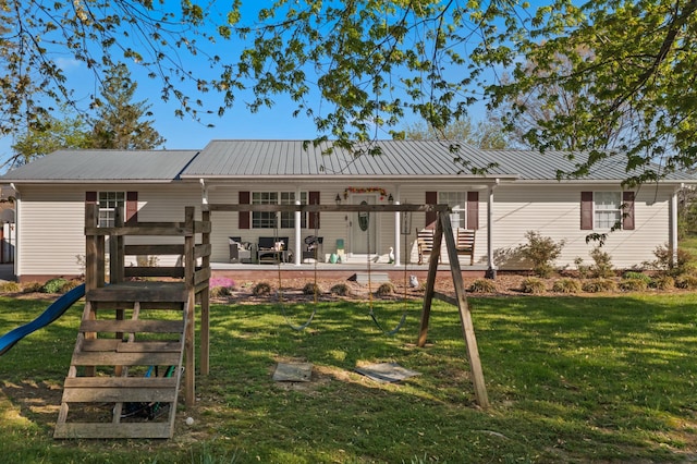 rear view of house featuring a yard and metal roof