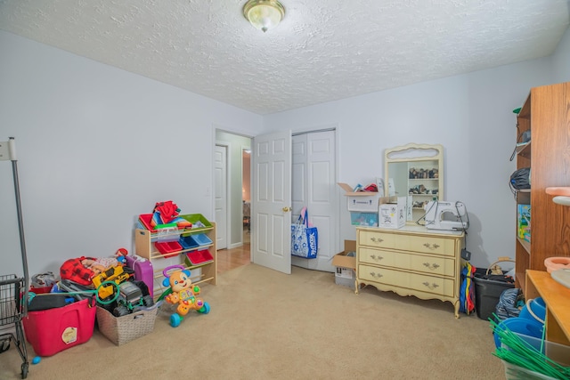 recreation room with carpet and a textured ceiling