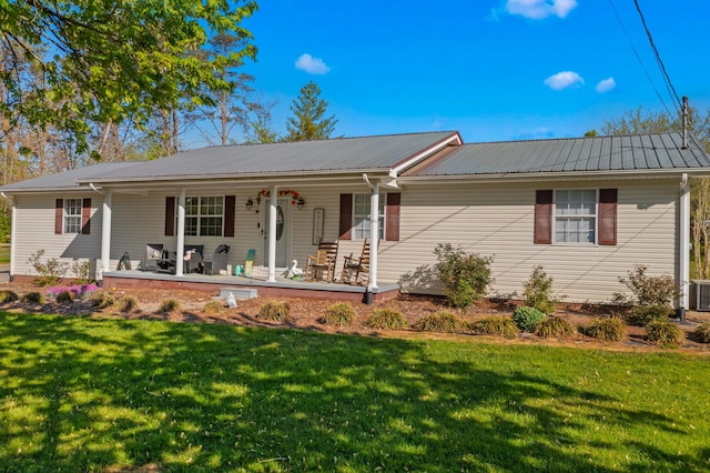 ranch-style home with central air condition unit, a front lawn, metal roof, and covered porch