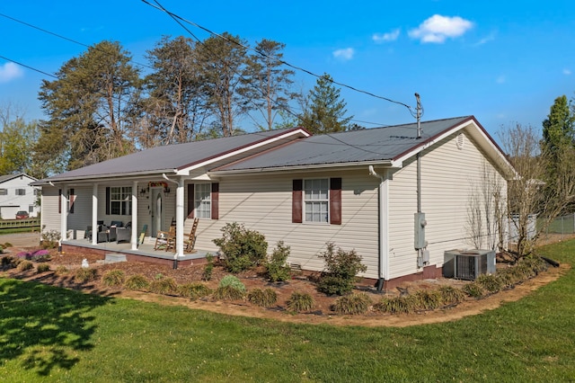 view of home's exterior featuring metal roof, a yard, and central AC unit