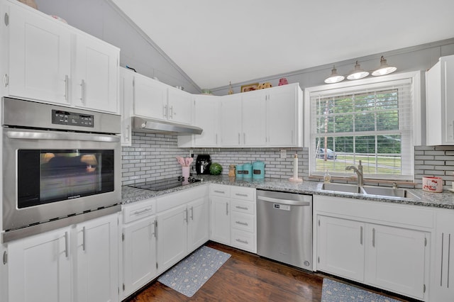 kitchen featuring sink, stainless steel appliances, tasteful backsplash, lofted ceiling, and white cabinets