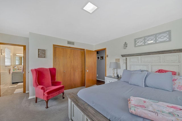 carpeted bedroom with ensuite bath and a closet