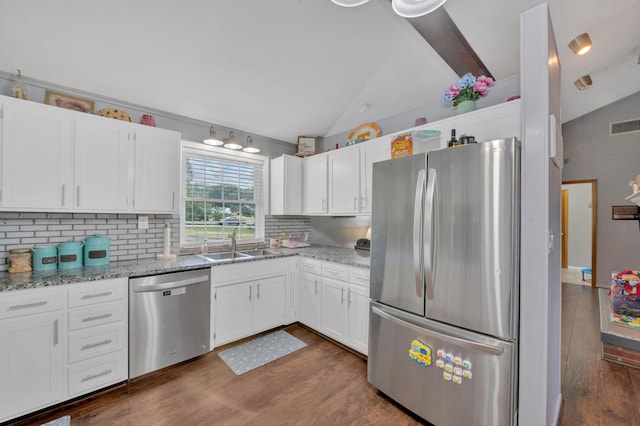 kitchen with white cabinets, appliances with stainless steel finishes, and vaulted ceiling