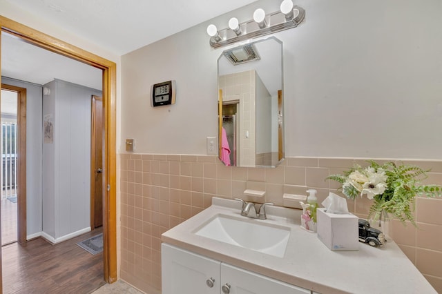 bathroom with vanity and tile walls