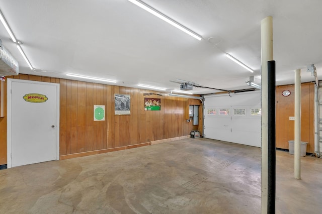 garage with electric panel, a garage door opener, and wooden walls