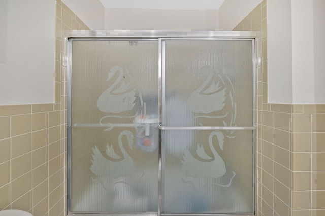 bathroom featuring tile walls and walk in shower