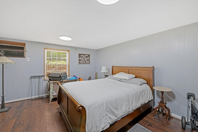 bedroom with a wall mounted air conditioner, wood walls, and dark hardwood / wood-style flooring