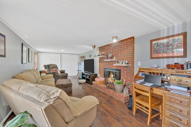 living room featuring dark hardwood / wood-style flooring, ornamental molding, and a fireplace