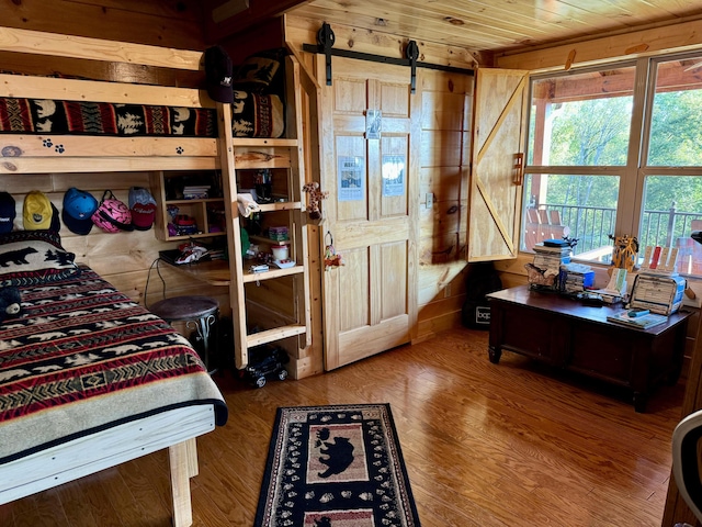 bedroom featuring wood ceiling, wood-type flooring, and wooden walls