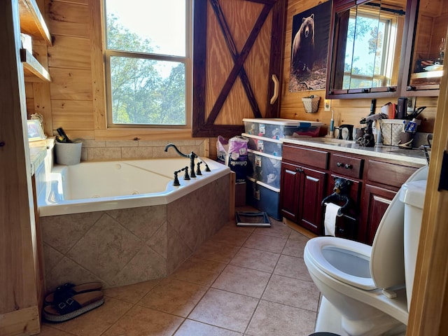 bathroom with tile patterned flooring, vanity, wooden walls, and tiled tub