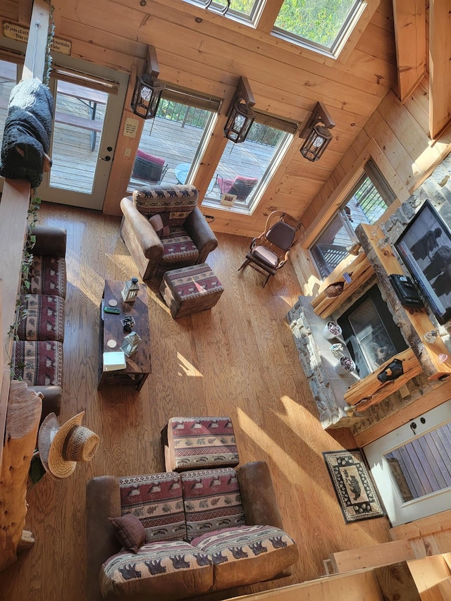 living room with wood walls, wooden ceiling, a wealth of natural light, and vaulted ceiling