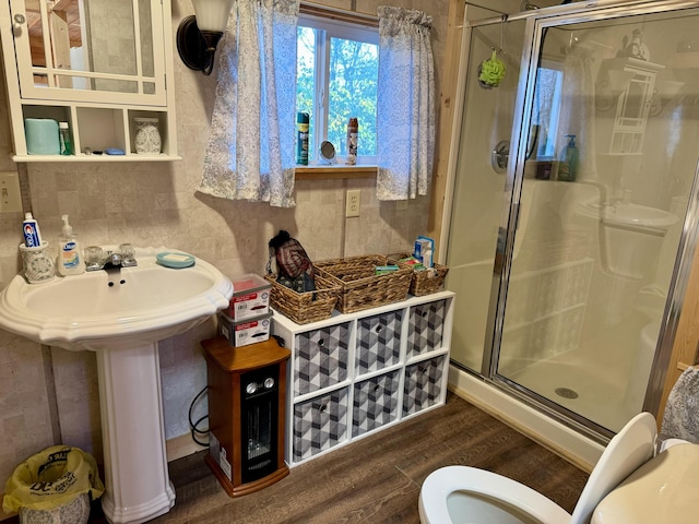 bathroom with toilet, sink, a shower with door, and hardwood / wood-style flooring