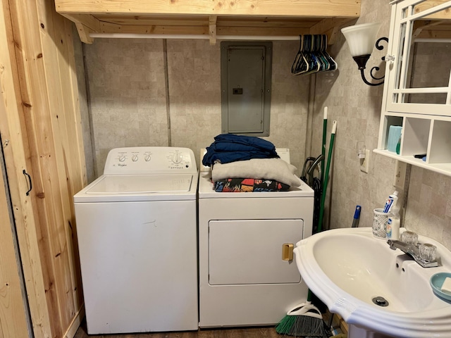 clothes washing area with separate washer and dryer, sink, and electric panel