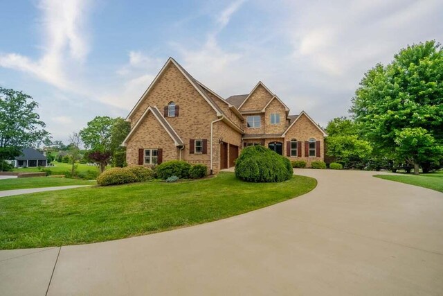 118 Luxury Ln, Dandridge, TN 37725 - view of front of property featuring curved driveway, brick siding, a front yard, and an attached garage