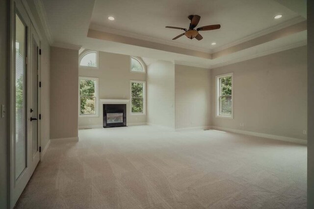 118 Luxury Ln, Dandridge, TN 37725 - unfurnished living room with a tray ceiling, a glass covered fireplace, carpet, baseboards, and crown molding