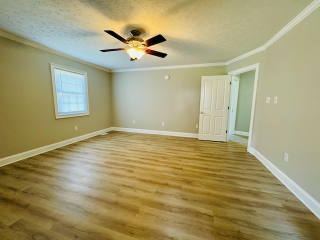 empty room featuring wood-type flooring, a textured ceiling, and ornamental molding