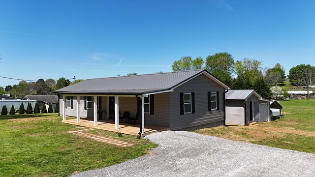 view of front of house featuring metal roof, a front yard, and driveway
