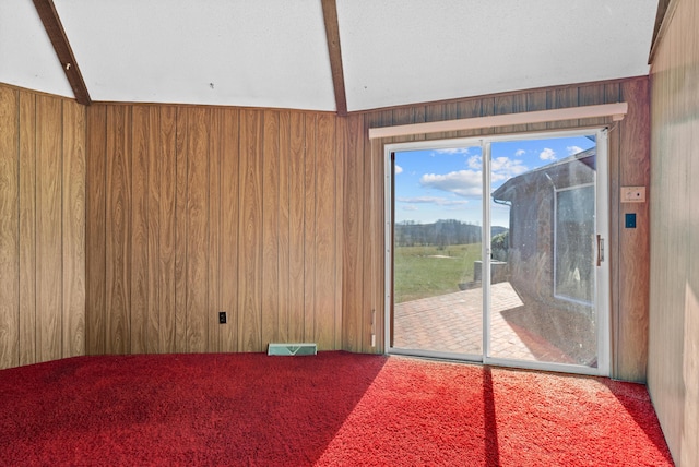 interior space with beamed ceiling, carpet flooring, and wood walls