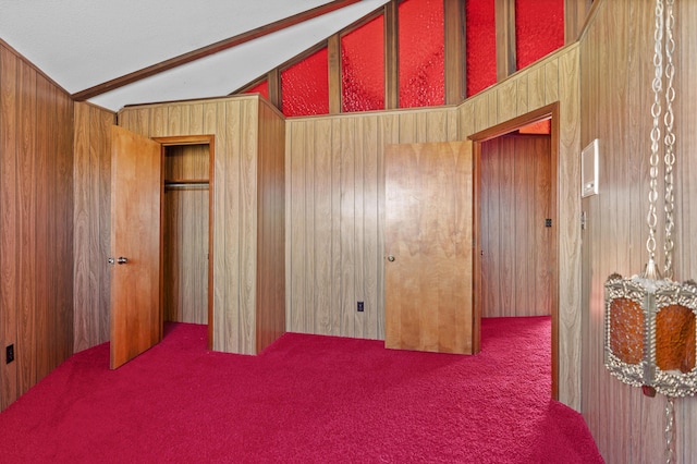 bedroom featuring lofted ceiling, carpet flooring, a closet, and wood walls